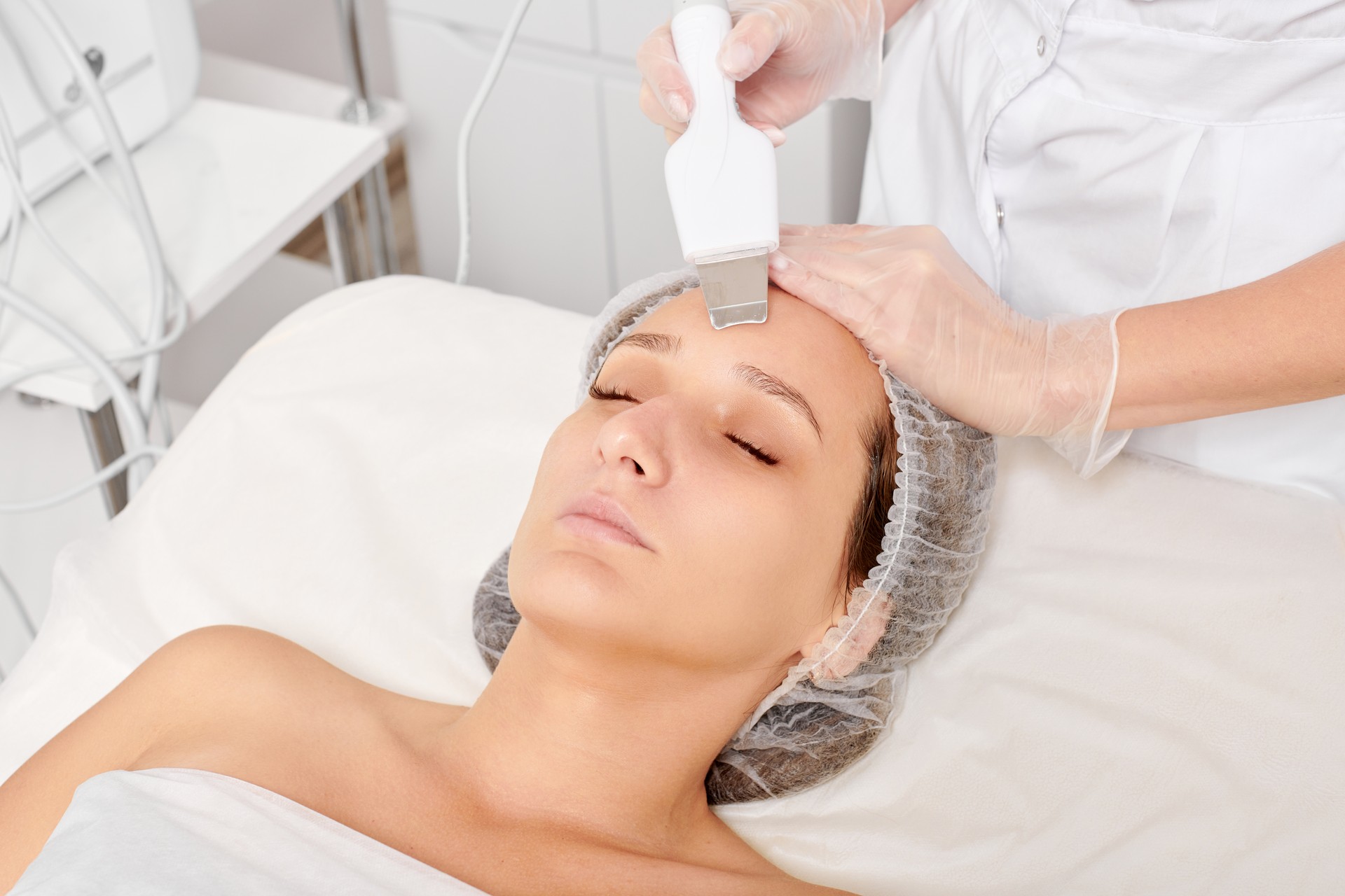 Beautician makes facial ultrasonic peeling for rejuvenation woman face skincare in beauty spa salon