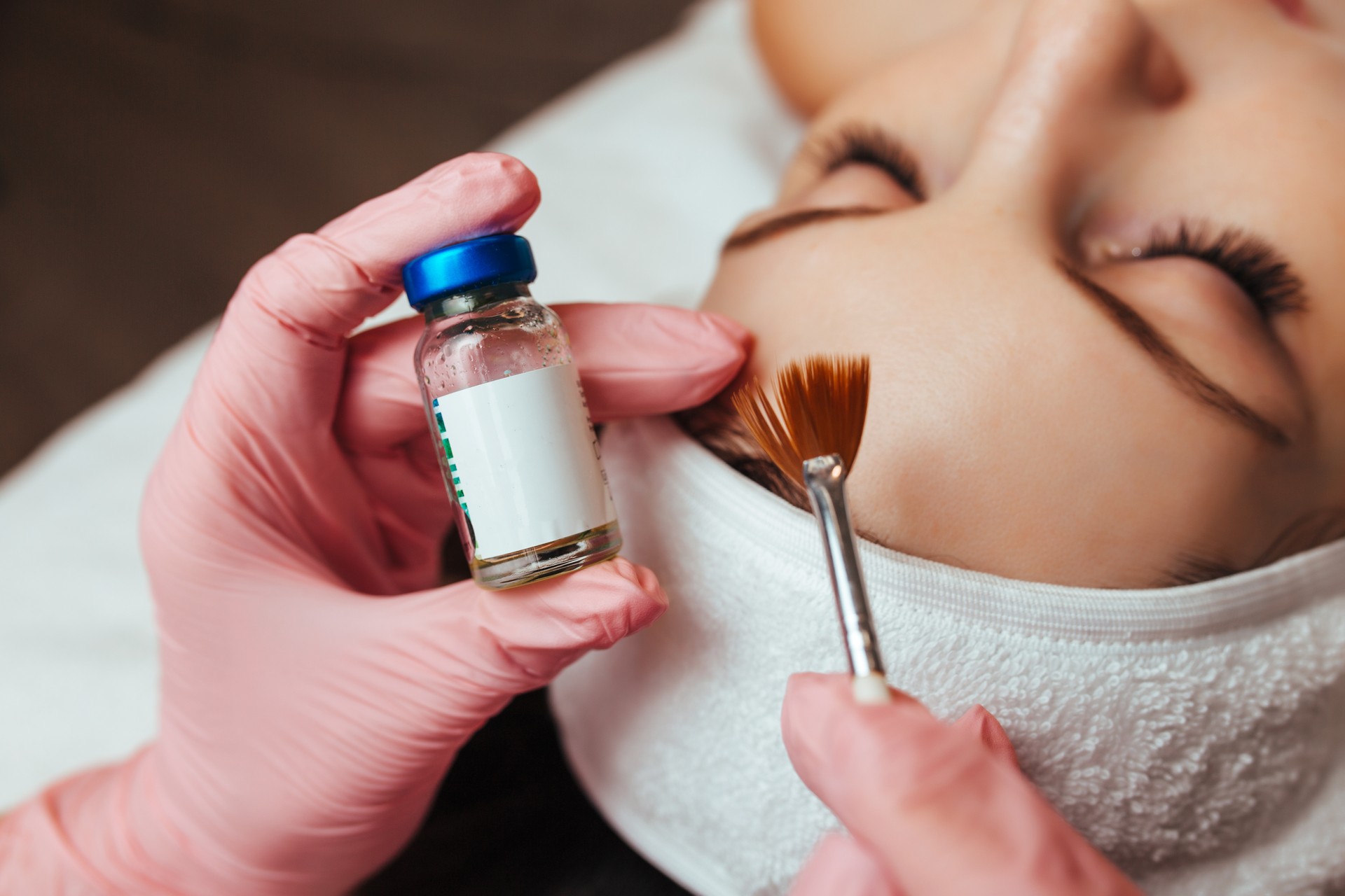 in the hands of a brush and a container with the drug, cosmetology chemical peeling